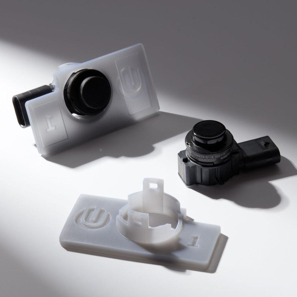 SLA 3D printed translucent automotive parking sensor brackets and sensor components.png